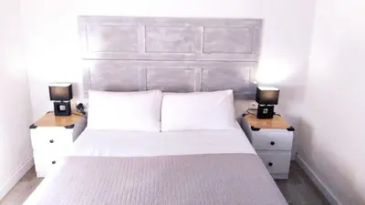 a bedroom with a white bed with two night stands at Acogedor apartamento en Valencia in Valencia