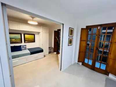 a living room with a couch and a blue pillow at Port Saplaya little Venice 10 days minimum in Port Saplaya