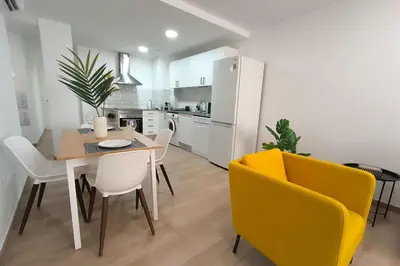 a kitchen and dining room with a table and chairs at White Lily in Godella
