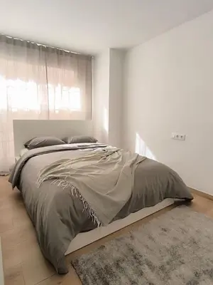 a bedroom with a large bed in a white room at White Lily in Godella