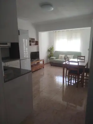 a kitchen and living room with a table and a couch at Estudio cerca de la playa in Valencia
