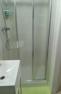 a shower with a glass door next to a sink at Estudio cerca de la playa in Valencia