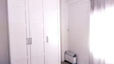 a white cabinet in a room with a window at Bonito apartamento en Valencia in Valencia