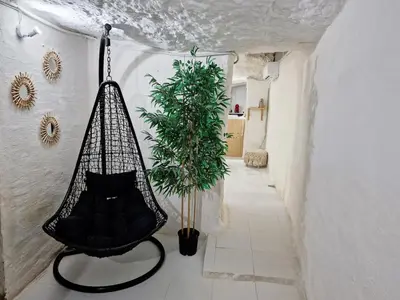 a black hammock sitting in a hallway with a plant at casa cueva a 15 minutos del centro de Valencia in Paterna