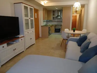 a living room with a couch and a tv and a table at vistas panoranicas al mar desde su terraza in Moncófar
