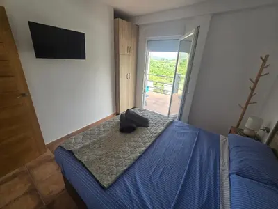 a bedroom with a bed with a blue comforter at Casa Rural El Bressol in Barraca de Aguas Vivas