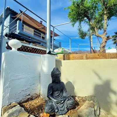 a statue of a buddha sitting next to a wall at Casa Rural El Bressol in Barraca de Aguas Vivas