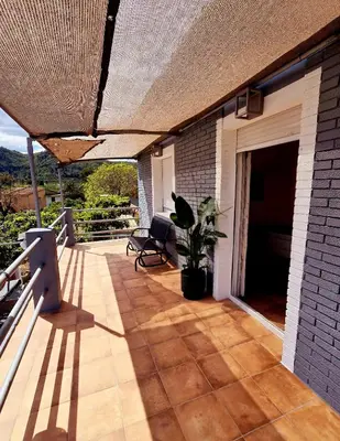 a patio with a couch and a plant on a porch at Casa Rural El Bressol in Barraca de Aguas Vivas