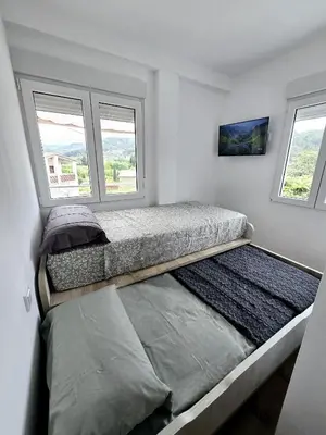 a bedroom with two beds and two windows at Casa Rural El Bressol in Barraca de Aguas Vivas