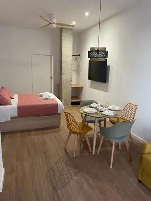 a bedroom with a bed and a table and chairs at Central Park Flats by VIVOGC in Valencia