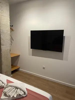 a flat screen tv hanging on a white wall at Central Park Flats by VIVOGC in Valencia