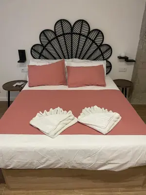 a bed with two white towels on top of it at Central Park Flats by VIVOGC in Valencia