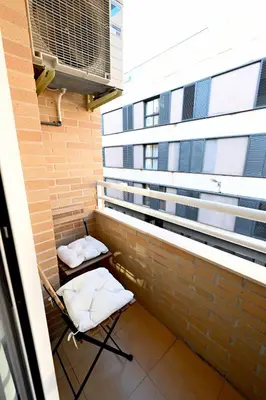 a balcony with two chairs and a building at EMMA Apartment in Puerto de Sagunto