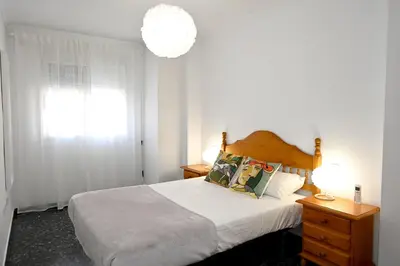 a bedroom with a bed and a chandelier at EMMA Apartment in Puerto de Sagunto