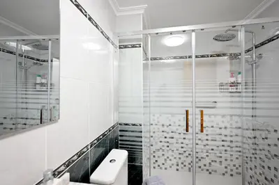 a white bathroom with a shower and a toilet at EMMA Apartment in Puerto de Sagunto