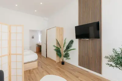 a bedroom with a bed and a tv on a wall at Stylish Studio with Easy Access to Valencias Best in Valencia