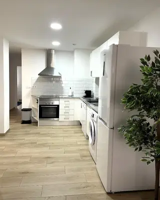a kitchen with white cabinets and a refrigerator at Little Rose apartment in Godella