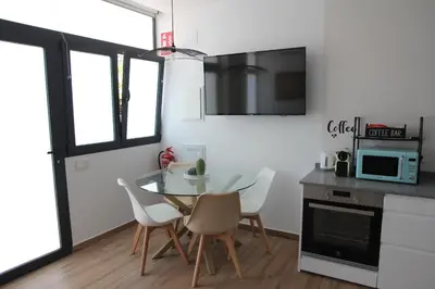a kitchen with a table and chairs and a microwave at Ruzafa Alegria in Valencia