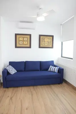 a blue couch in a living room with white walls at Ruzafa Alegria in Valencia