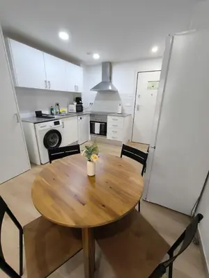 a kitchen with a wooden table and chairs in a room at Cute little apartment in Godella