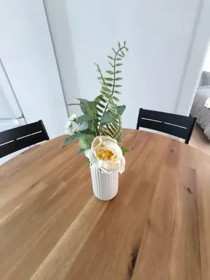 a vase of flowers sitting on top of a wooden table at Cute little apartment in Godella