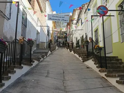 a street in an old town with stairs and flags at Brisas del Lago in Navarrés