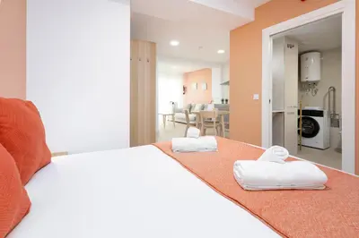 a bedroom with a white bed with towels on it at Apartamentos Sol de Azahar in Valencia