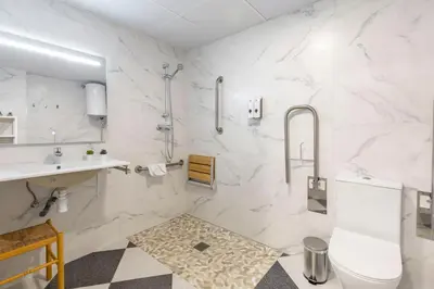 a white bathroom with a sink and a toilet at Apartamentos Sol de Azahar in Valencia