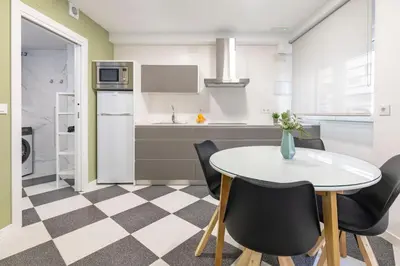 a kitchen with a white table and chairs at Apartamentos Sol de Azahar in Valencia