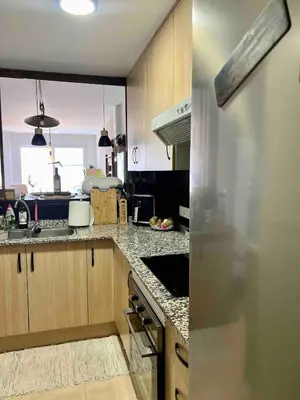 a kitchen with wooden cabinets and a counter top at Apartment with the pool in Moncófar