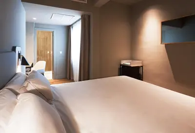 a bedroom with a large white bed and a television at One Shot Colón in Valencia