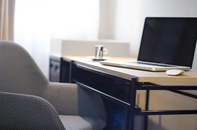 a laptop computer sitting on a desk with a chair at One Shot Colón in Valencia