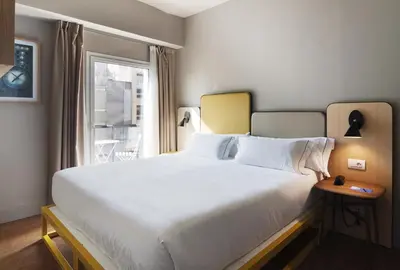 a bedroom with a large white bed with a window at One Shot Colón in Valencia