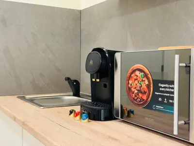 a microwave oven sitting on a counter next to a kitchen counterasteryasteryasteryastery at Suite Palacio Congresos in Valencia