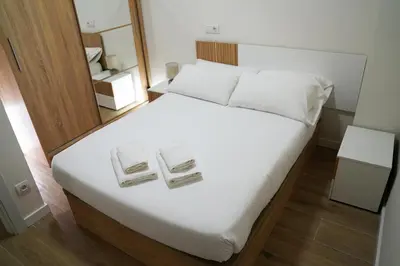 a bedroom with a white bed with two towels on it at Casa Dolce Casa - Elegant 3BR Apartment Near Metro & Beach,Valencia in Valencia