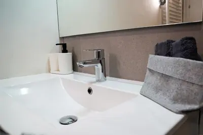 a bathroom sink with a faucet and a mirror at Casa Dolce Casa - Elegant 3BR Apartment Near Metro & Beach,Valencia in Valencia