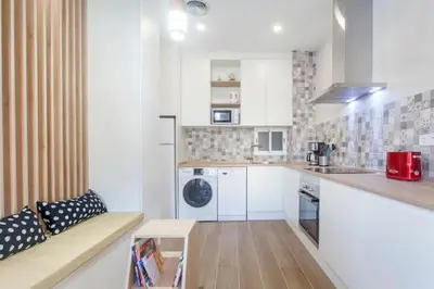 a kitchen with white cabinets and a couch in a room at new apartment 4 pax front central station wifi in Valencia