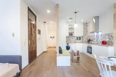 a living room and kitchen with a couch and a table at new apartment 4 pax front central station wifi in Valencia