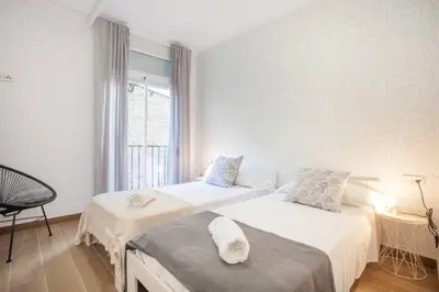 a white room with two beds and a window at new apartment 4 pax front central station wifi in Valencia