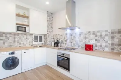 a kitchen with white cabinets and a washing machine at new apartment 4 pax front central station wifi in Valencia