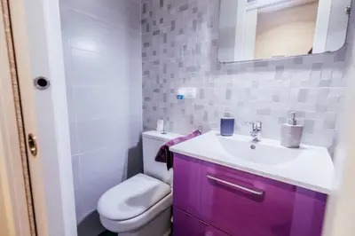 a bathroom with a purple sink and a toilet at Queen Apt, 2min to Beach, Terrace, 3BD, 6PAX in Valencia