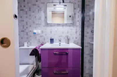 a purple bathroom with a sink and a mirror at Queen Apt, 2min to Beach, Terrace, 3BD, 6PAX in Valencia