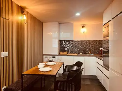 a small kitchen with a wooden table and chairs at Dúplex tipo loft de estilo selvático y safari, con encanto y a pasos del mar in Valencia
