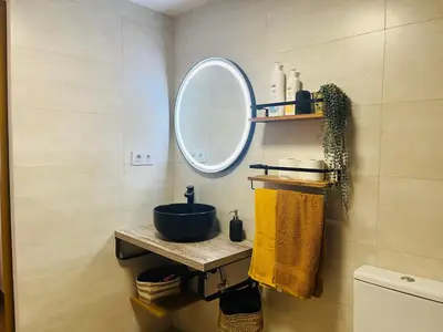 a bathroom with a sink and a mirror at Dúplex tipo loft de estilo selvático y safari, con encanto y a pasos del mar in Valencia