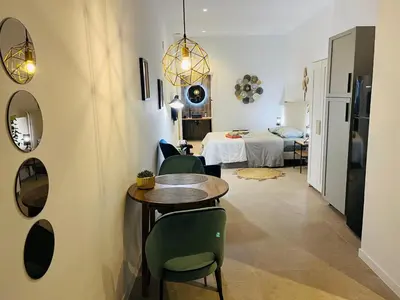 a room with a table and chairs and a bedroom at Hotel con entrada independiente a pocos pasos de la Ciudad de las Artes y las Ciencias y el Oceanogràfic A solo 1 minuto caminando del Jardín del Turia in Valencia
