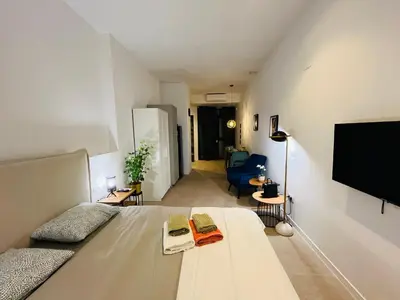a living room with a bed and a flat screen tv at Hotel con entrada independiente a pocos pasos de la Ciudad de las Artes y las Ciencias y el Oceanogràfic A solo 1 minuto caminando del Jardín del Turia in Valencia