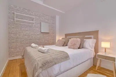 a bedroom with a large white bed with towels on it at Romantic Suite Roig Arena N10 Virkin Suites in Valencia