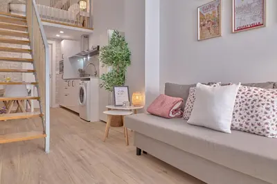 a living room with a gray couch and a staircase at Romantic Suite Roig Arena N10 Virkin Suites in Valencia