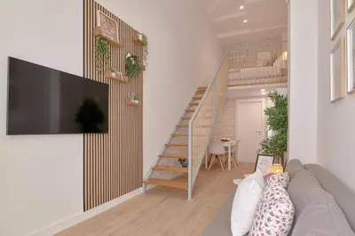 a living room with a couch and a staircase at Romantic Suite Roig Arena N10 Virkin Suites in Valencia