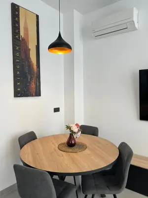 a dining room table with chairs and a vase with flowers at Mistral Suites in Valencia